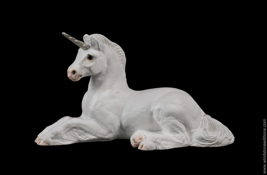 Resting Ponycorn fantasy figurine in white with silver colored detail. Hand-painted collectible sculpture by Windstone Editions